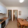 Cucina-soggiorno con tavolo da pranzo e fornelli.