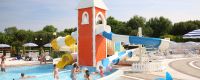 Una piscina con scivoli colorati e bambini che giocano.